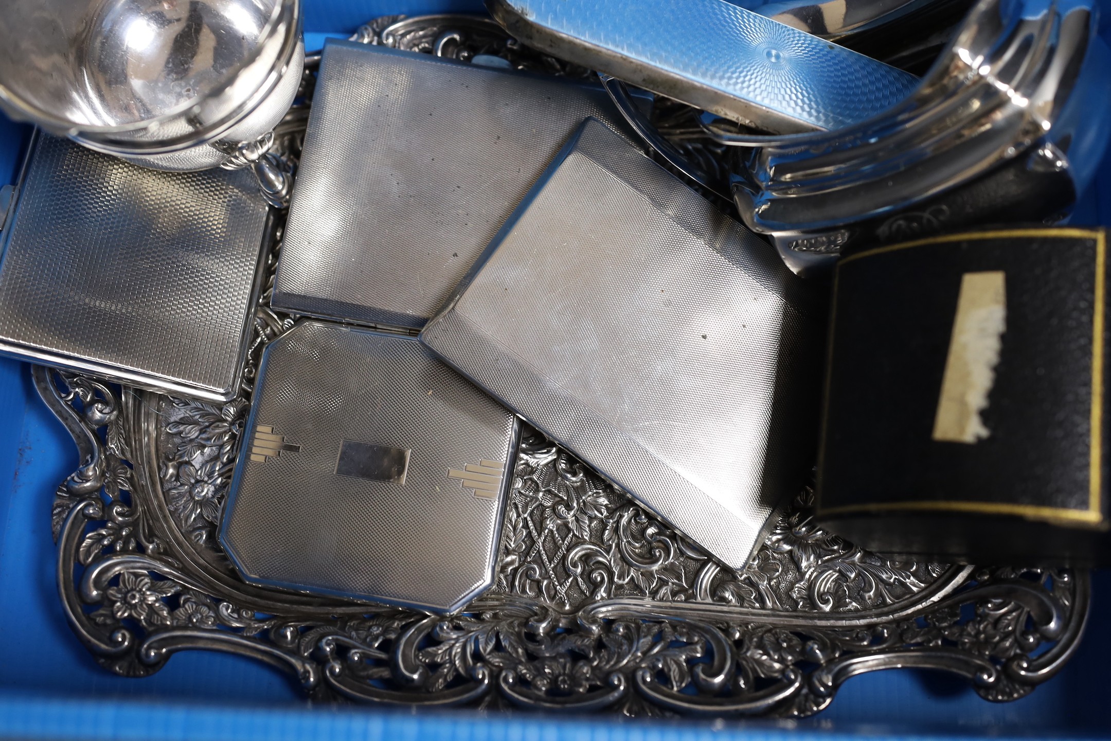 A collection of small silver including a repousse dressing tray, cream jug, sugar bowl, pepperette, sauceboat, two cigarette cases, compact, napkin ring and a mounted enamel mirror and brush set, weighable silver 41.5oz.